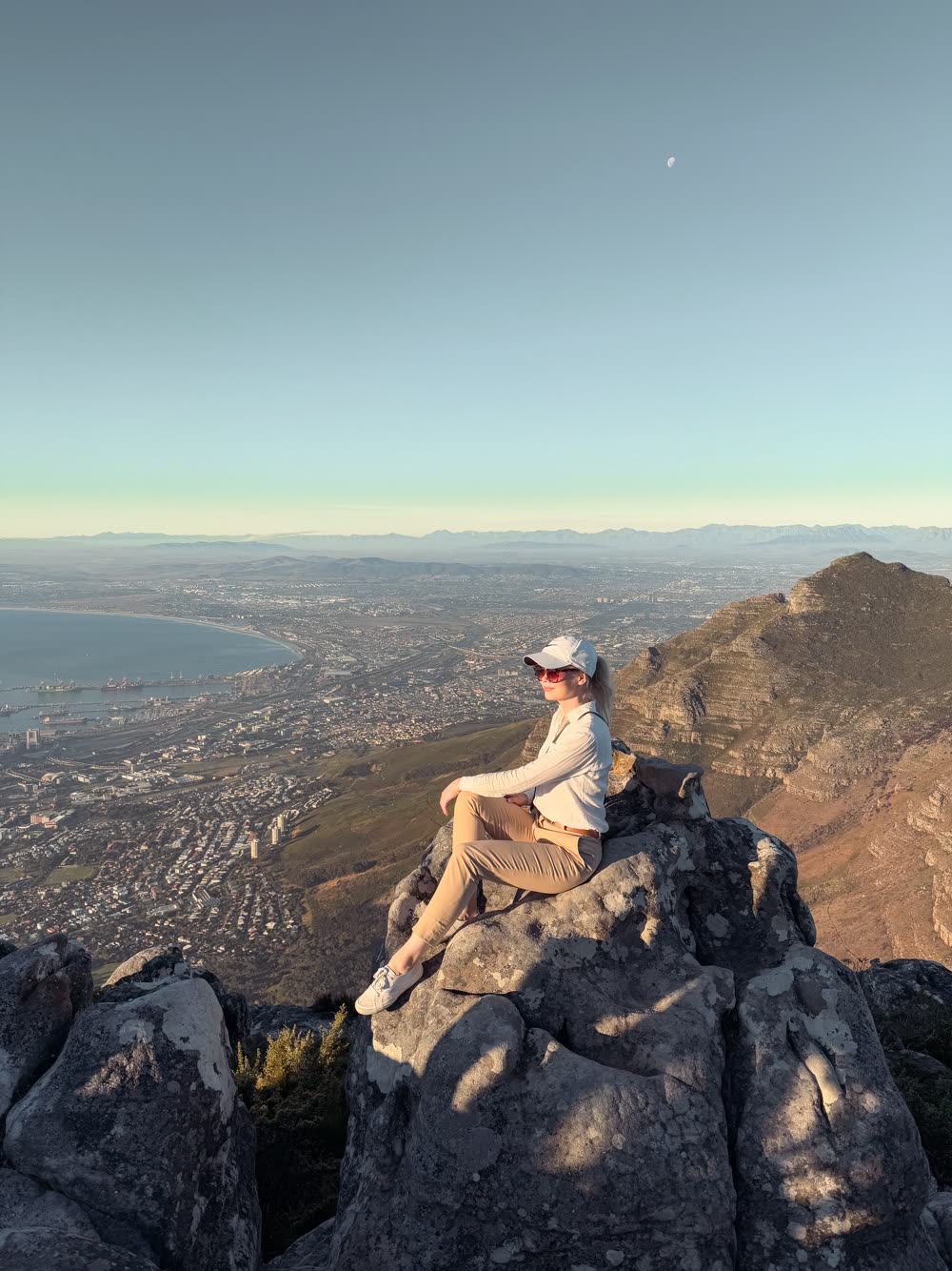 Greta sitting on a rock at the top of Table Mountain, looking out over Cape Town